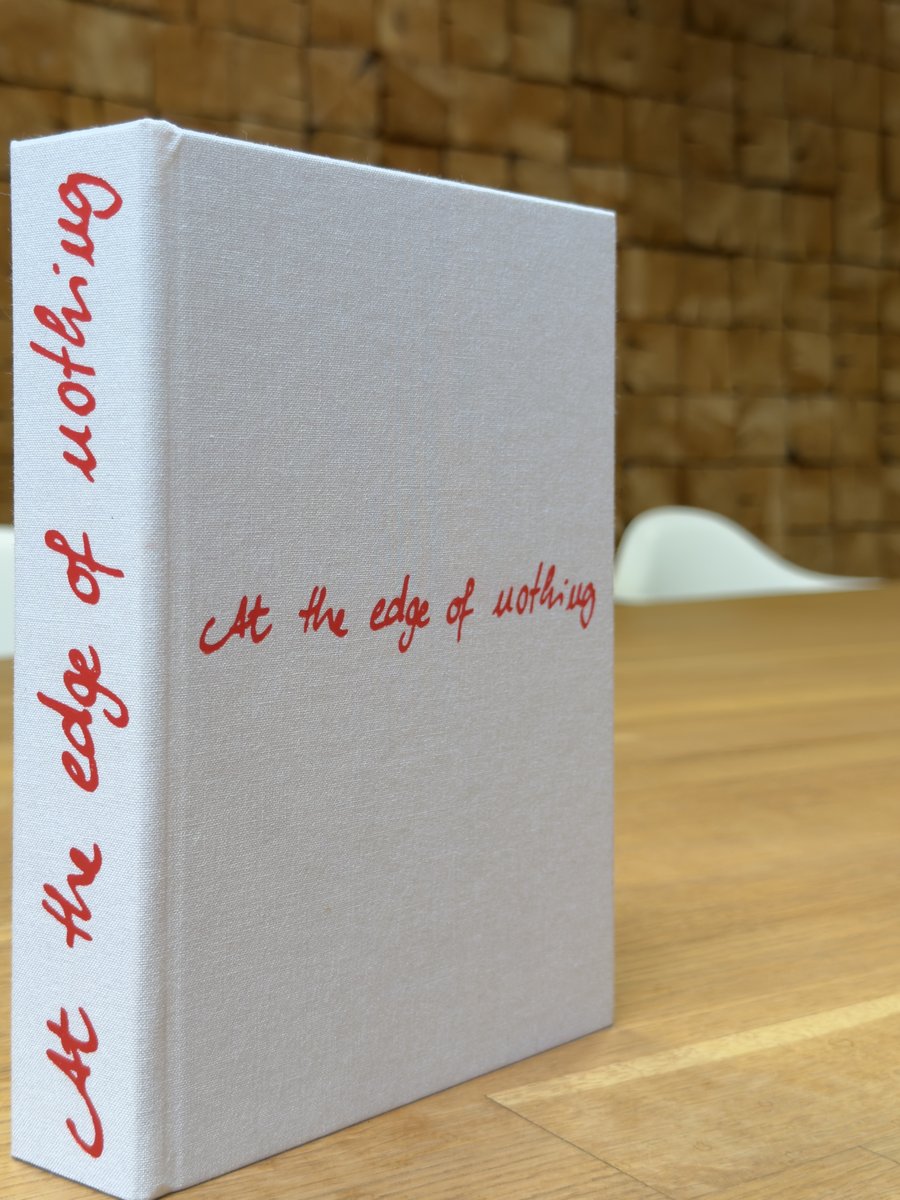 Helles Leinenbuch mit roter Prägung auf dem Buchrücken – At the Edge of Nothing